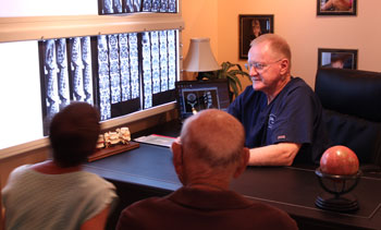 Friendly chiropractic doctor talks with couple.